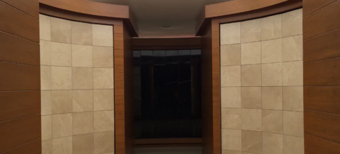 Criptas Muro de nichos en mármol beige, rodeado de marcos en madera curvos