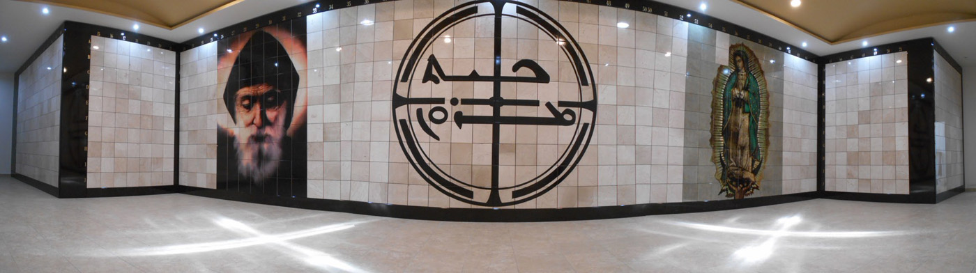Criptas Muro de mármol con imágenes de un santo, un símbolo religioso, y la Virgen de Guadalupe.