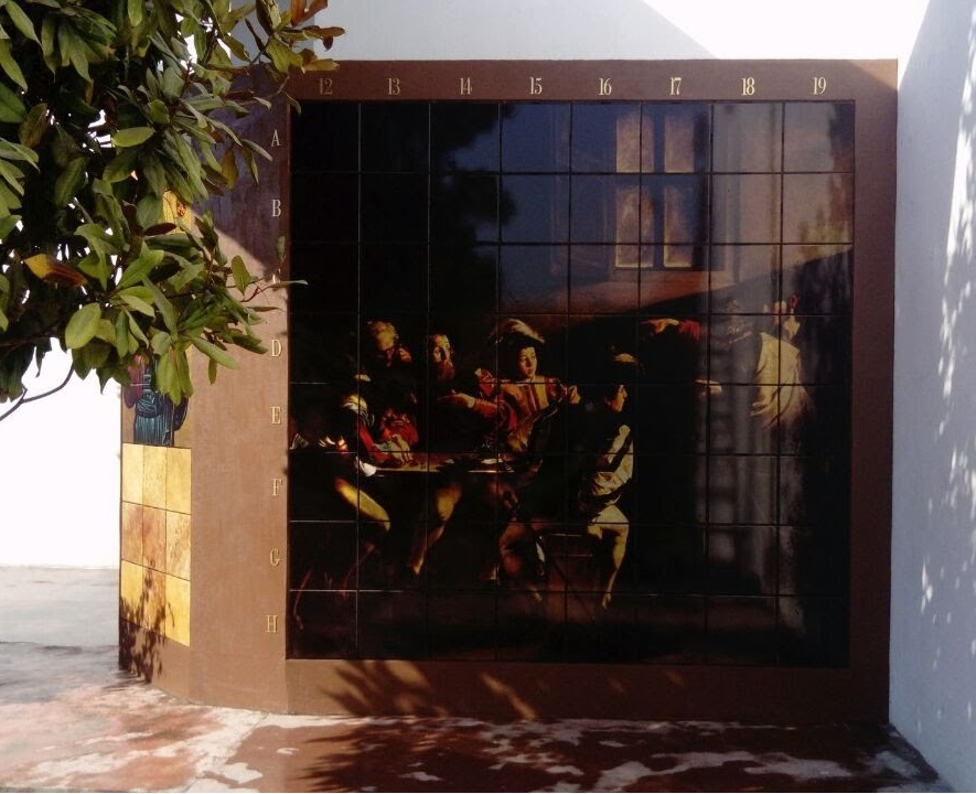 Criptas Mural de nichos con imagen oscura en tonos cálidos que representa una escena religiosa clásica. A la izquierda, otro conjunto de nichos en tonos marrones