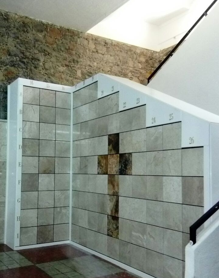 Criptas Pared con nichos de mármol organizados en una estructura escalonada, con un diseño de cruz en el centro